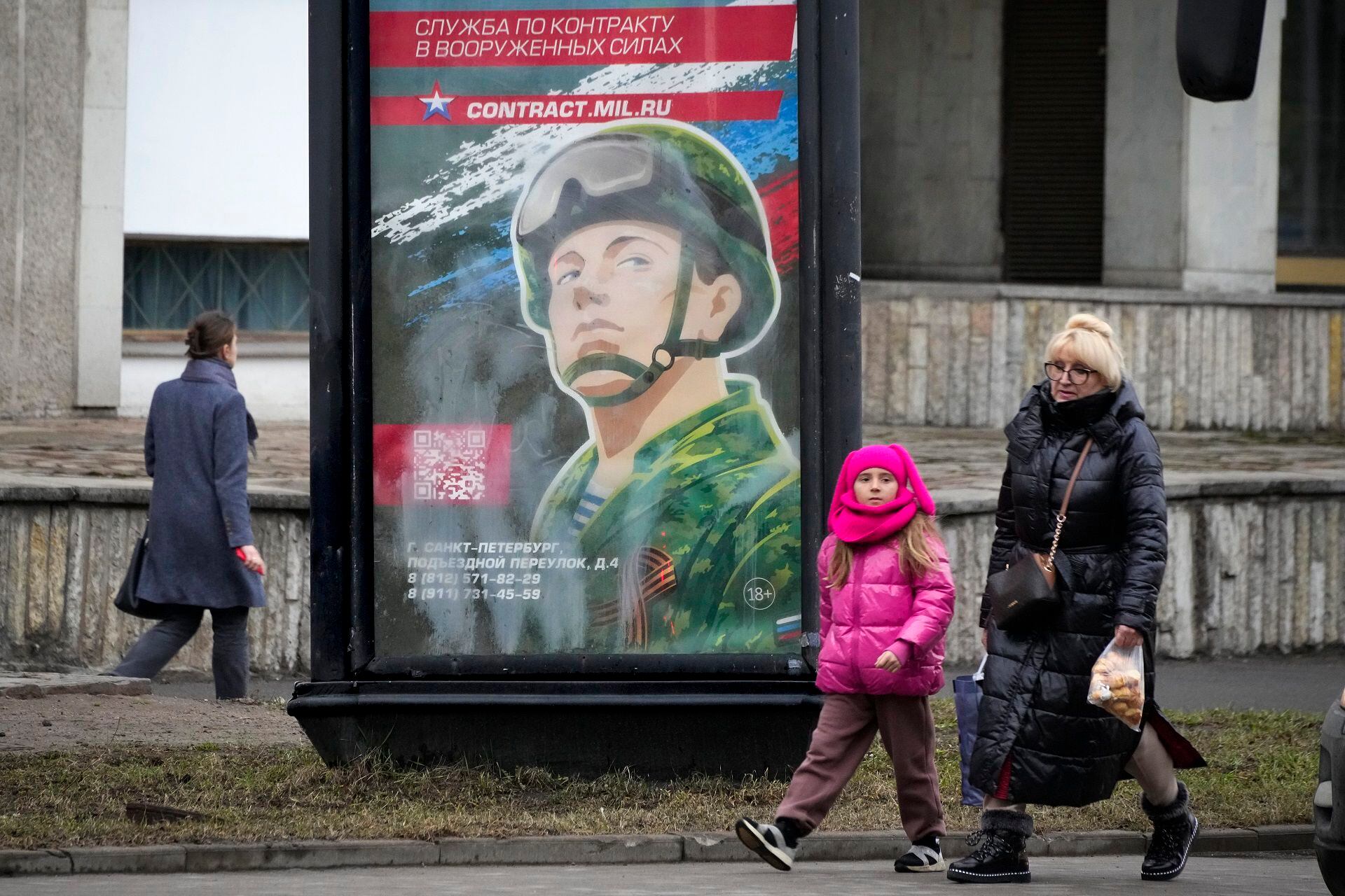People walk past an army recruiting billboard with the words "Military service under contract in the armed forces" in St. Petersburg, Russia, Friday, March 24, 2023. A campaign to replenish Russian troops in Ukraine with more soldiers appears to be underway again, with makeshift recruitment centers popping up in cities and towns, and state institutions posting ads promising cash bonuses and benefits to entice men to sign contracts enabling them to be sent into the battlefield. (AP Photo)