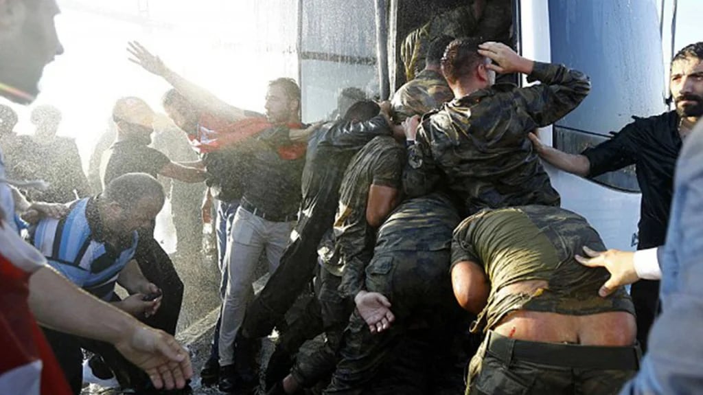 Algunos de los soldados golpistas son subidos bruscamente a un transporte luego de ser arrestados por policías y civiles leales (Reuters)