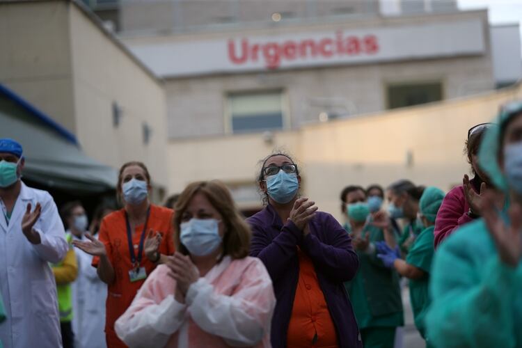 Personal médico saluda ante los aplausos de los vecinos en Madrid (Reuters)