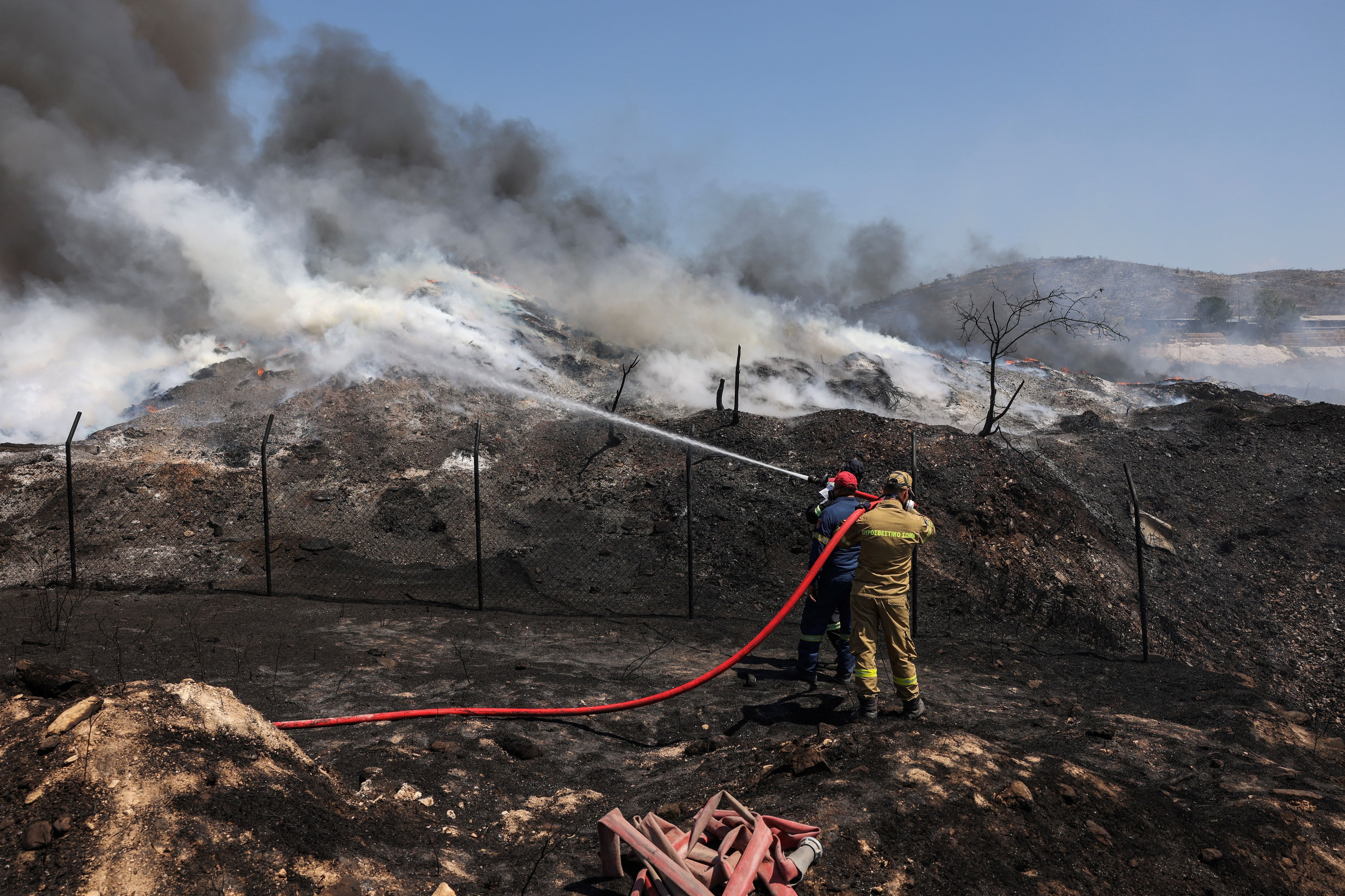 Los bomberos intentan extinguir un incendio en una planta de reciclaje, en Sesklo, en el centro de Grecia, el 26 de julio de 2023. REUTERS/Alexandros Avramidis