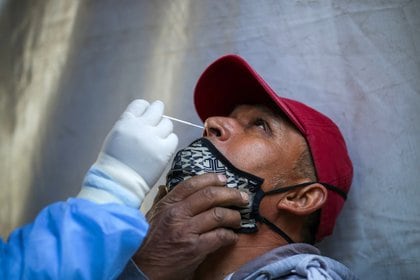 A healthcare worker wearing personal protective equipment (PPE) takes a swab sample from a man for the coronavirus disease (COVID-19) rapid antigen testing at the Iztapalapa neighbourhood in Mexico City, Mexico, February 5, 2021. REUTERS/Henry Romero