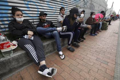 En esta imagen del 30 de abril de 2020, migrantes venezolanos esperando a los autobuses que les llevarán a la frontera venezolana, en Bogotá, Colombia. Los migrantes quieren regresar a su país porque dicen que no pudieron encontrar trabajo por el cierre de negocios ordenado en Colombia para combatir el coronavirus. (AP Foto/Fernando Vergara)