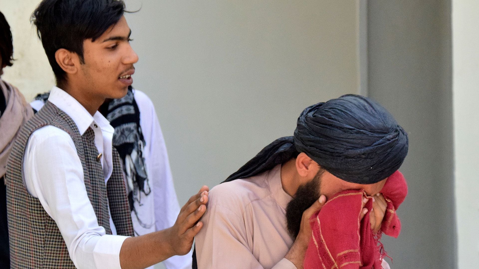 Un hombre consuela a otro de luto por su pariente, que murió en la explosión de una bomba, en un hospital, en Quetta, Pakistán, viernes 29 de septiembre de 2023 (AP/Arshad Butt)
