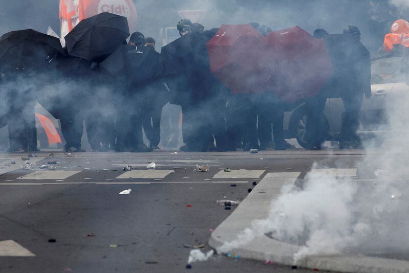 Manifestantes se protegen con paraguas en medio de gases lacrimógenos durante los enfrentamientos en una manifestación como parte del décimo día de huelgas y protestas contra la reforma de las pensiones del Gobierno francés en Nantes, Francia. 28 de marzo de 2023.   REUTERS/Stephane Mahe