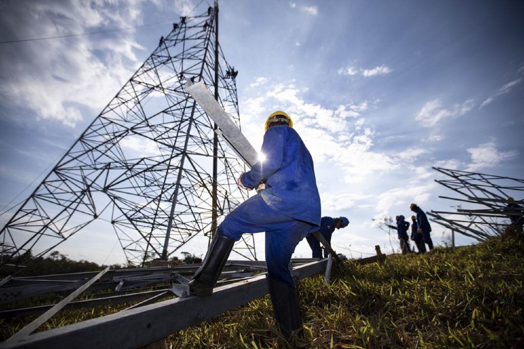 Un trabajador instala una torre de alta tensión.