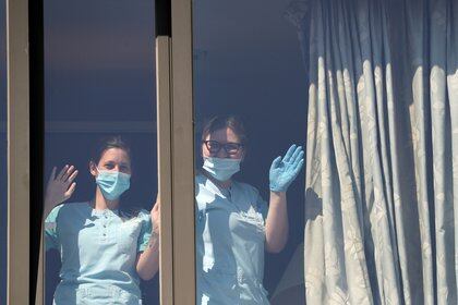 Las enfermeras miran por la ventana de un centro de cuidados para personas mayores (Reuters / archivo)