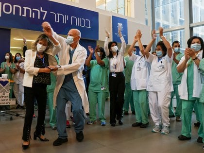Los profesionales de la salud celebran después de recibir la vacuna COVID-19 en un hospital de Tel Aviv, Israel (REUTERS / Ronen Zvulun)