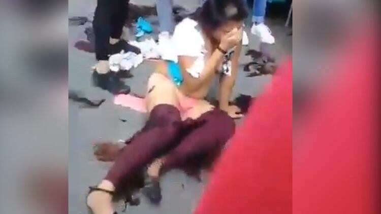 Ambas mujeres casi quedaron desnudas después de que unas comerciantes rompieran sus ropas con unas tijeras (Foto: captura de pantalla)