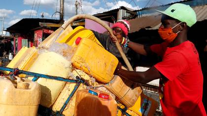 Un vendedor llena bidones de agua para su venta, en medio de la escasez de agua durante la propagación del brote de coronavirus en Nairobi, Kenia, el 13 de mayo de 2020 (REUTERS/Njeri Mwangi)