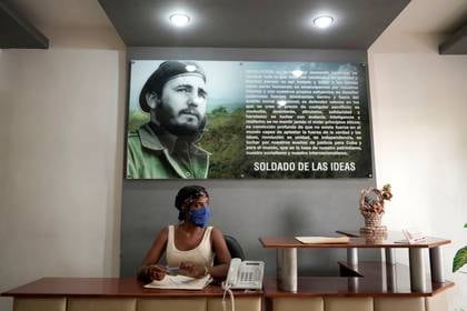 Una empleada pública con una mascarilla en un edificio estatal en Zaragoza, Cuba, el 28 de abril de 2020. (REUTERS/Alexandre Meneghini)