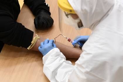 Foto de archivo: Un trabajador médico toma una muestra de sangre de un hombre para analizar la enfermedad por coronavirus (COVID-19) en un gimnasio convertido en Cisliano, cerca de Milán, Italia, el 21 de abril de 2020 (Reuters/ Flavio Lo Scalzo /archivo)