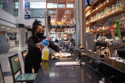 Una mujer limpia y desinfecta un restaurante de la Terminal E del Aeropuerto Intercontinental George Bush de IAH en medio del brote de la enfermedad coronavirus en Houston, Texas (Reuters)