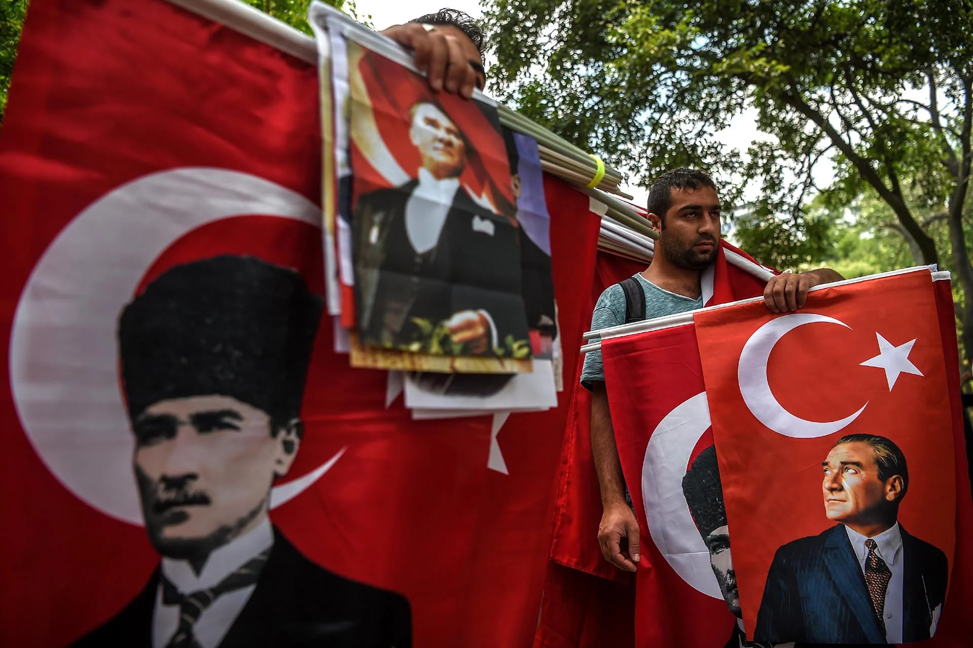 Vendedores de banderas en Estambul sostienen los retratos de Mustafa Kemal Ataturk, fundador de la Turquía moderna, durante una demostración de seguidores del principal partido de la oposición de Turquía para protestar por el encarcelamiento de uno de sus diputados