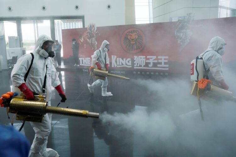 Voluntarios desinfectan las instalaciones del gran teatro de Qintai, en Wuhan. 