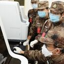 Científicos militares chinos observan un monitor en un laboratorio en el que se investiga los alcances del coronavirus COVID-19 (AMMS)