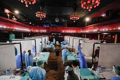 Trabajadores sanitarios se preparan para recoger muestras de hisopos de personas, antes de un concierto de "Love of Lesbian" 