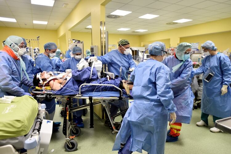 Varios miembros del personal médico trasladan a un paciente de 18 años con coronavirus a una unidad de cuidados intensivos en el hospital San Raffaele de Milán, Italia, el 27 de marzo de 2020 (REUTERS/Flavio Lo Scalzo)
