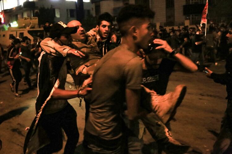 Un herido es transportado al hospital en medio de las protestas en Irak (Photo by - / AFP)