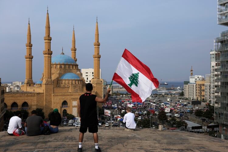 Un manifestante contrario al gobierno ondea una bandera libanesa durante una protesta en Beirut, Líbano, el 25 de octubre de 2019. (AP Foto/Hassan Ammar)