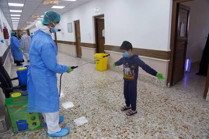 Una enfermera desinfecta a un menor en Najaf, Iraq . REUTERS/Alaa al-Marjani
