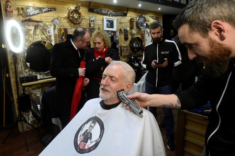 El líder del opositor Partido Laborista británico Jeremy Corbyn se corta la barba en el marco de un acto de campaña en Carmarthen, el 7 de diciembre de 2019 (REUTERS/Rebecca Naden)