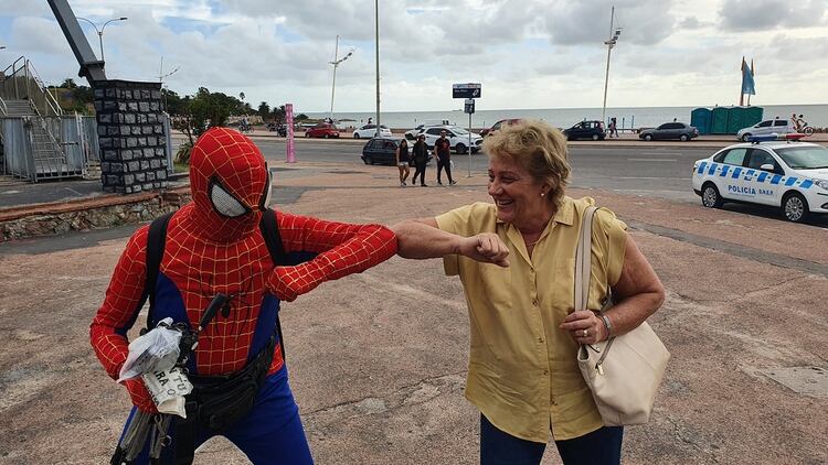 El Hombre Araña de Montevideo saluda a una mujer con el codo para evitar el contagio de coronavirus