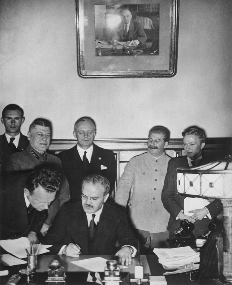 El ministro de Exteriores soviético Viacheslav Molotov firma en Moscú el pacto de no agresión con Alemania, el 23 de agosto de 1939. Justo a sus espaldas, su par germano Joachim von Ribbentrop y, a su lado, Josef Stalin (Bundesarchiv)