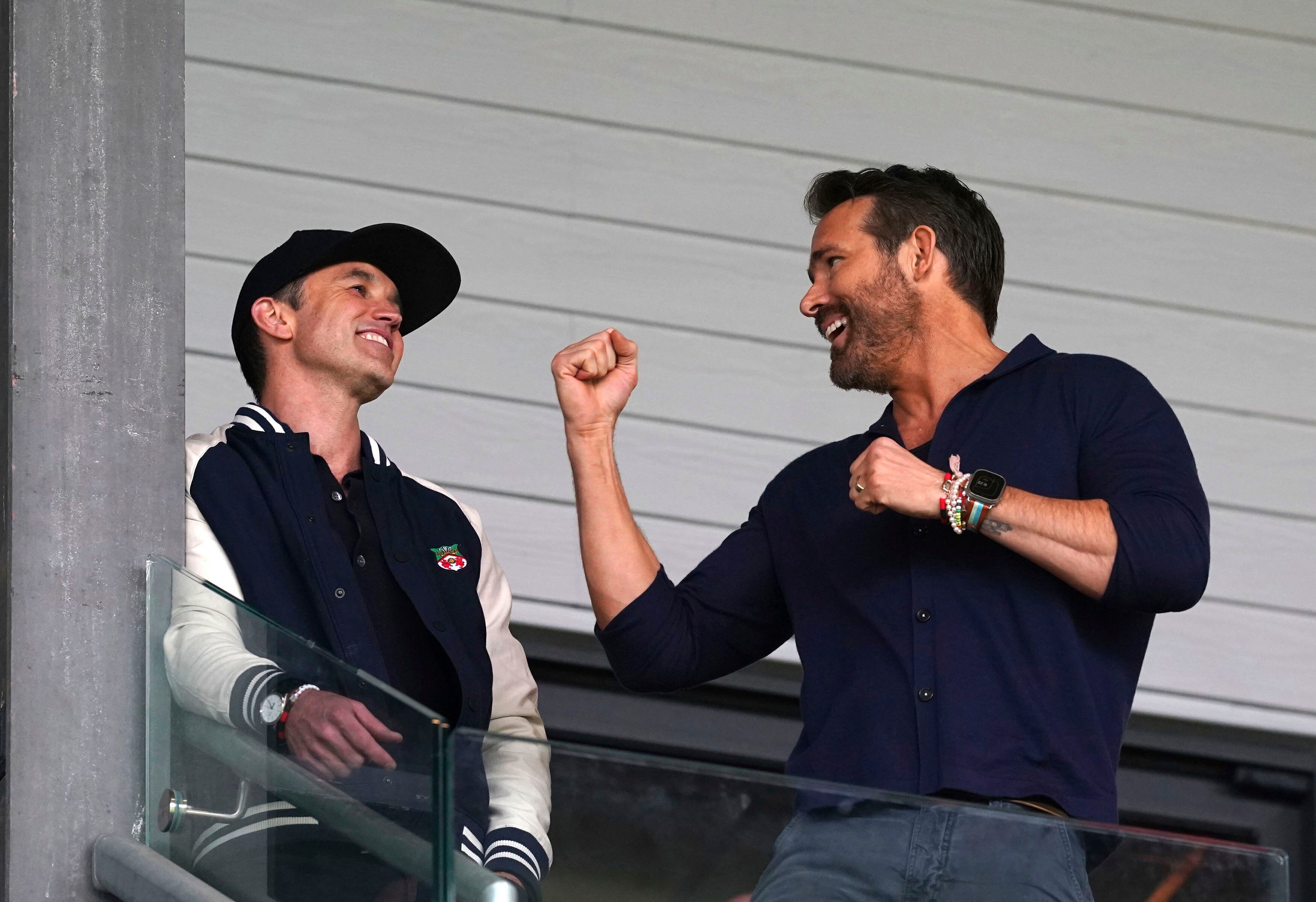 Los actores Rob McElhenney (izquierda) y Ryan Reynolds, codueños de Wrexham, celebran durante el partido contra Boreham Wood, el sábado 22 de abril de 2023, en el estadio Racecourse Ground. (Martin Rickett/PA vía AP)