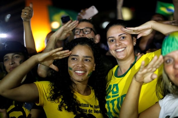 Simpatizantes de Bolsonaro celebran en Brasilia el resultado de la elección con el típico gesto del candidato derechista (REUTERS/Adriano Machado)