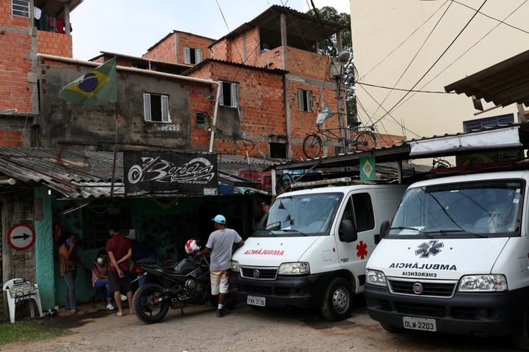 Un grupo de personas se reúne en torno a unas ambulancias dispuestas para ser utilizadas por los vecinos de una favela en Sao Paulo, que contrató a un equipo privado para hacer frente al brote de coronavirus en Sao Paulo, Brasil, el 29 de marzo de 2020. REUTERS/Amanda Perobelli