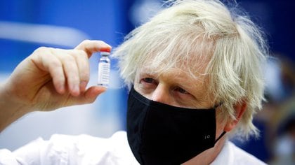 FILE PHOTO: Britain's Prime Minister Boris Johnson holds a vial of an Oxford-AstraZeneca COVID-19 vaccine, during his visit at a vaccination centre at Cwmbran Stadium in Cwmbran, south Wales, Britain February 17, 2021. Geoff Caddick/Pool via REUTERS/File Photo