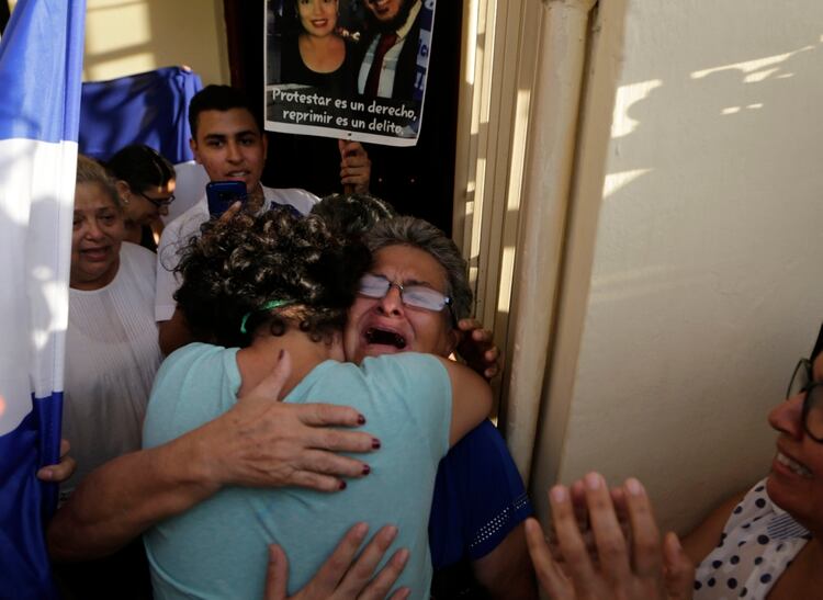 Maria Adilia Peralta abraza a una familiar en su casa (INTI OCON / AFP)