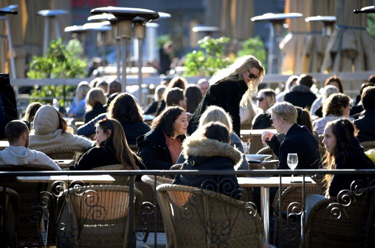 La gente disfruta del sol en un restaurante al aire libre, a pesar de la continua propagación de la enfermedad por coronavirus COVID-19, en Estocolmo, Suecia (Reuters)
