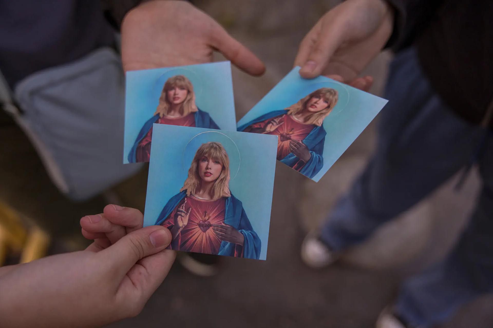 Maria Claude Arzapalo y sus amigas con tarjetas que muestran a Taylor Swift como Jesús