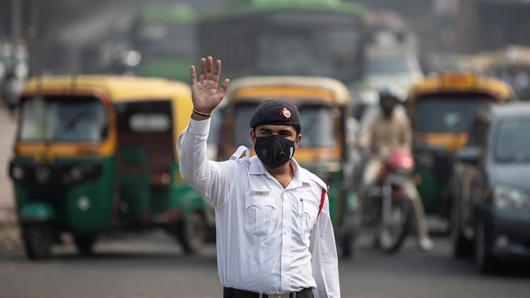 Un policía de tránsito vigila el cumplimiento de las restricciones, protegido con una mascarilla (Reuters)