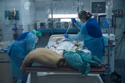 Personal sanitario atiende a un paciente afectado por la covid-19 en la Unidad de Cuidados Intensivos del Hospital Clínico de la Universidad de Chile, en Santiago. EFE/Alberto Valdés/Archivo
