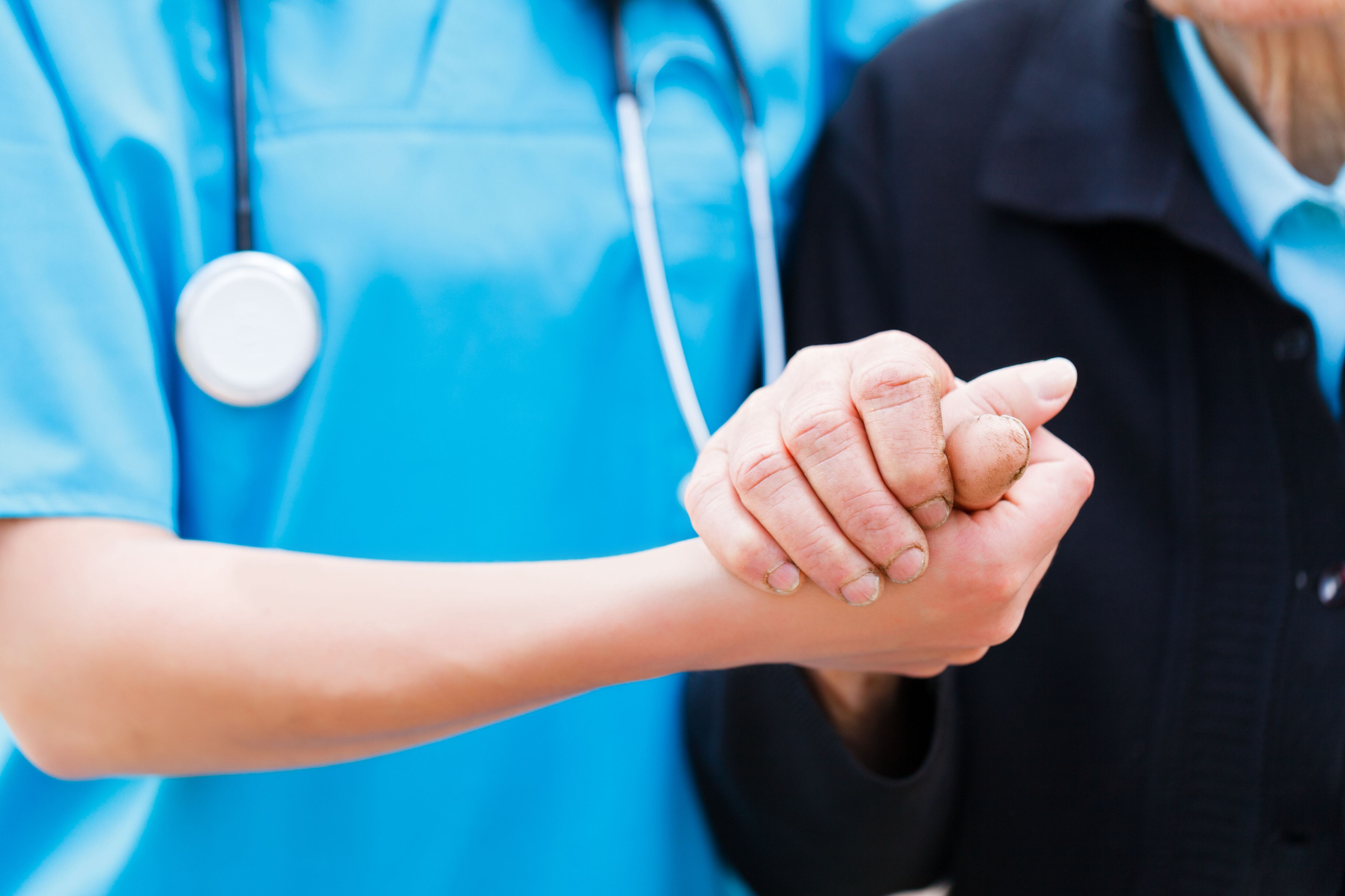 Una enfermera sostiene la mano de una persona con Alzheimer (Shutterstock)