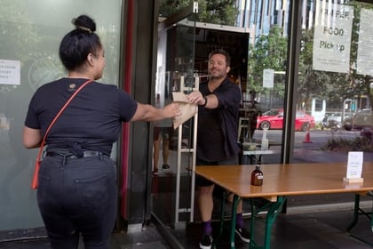 A customer collects takeaway food in the wake of New Zealand easing strict regulations implemented to curb the spread of the coronavirus disease (COVID-19) in Auckland, New Zealand April 28, 2020.  REUTERS/Ruth McDowall  NO RESALES. NO ARCHIVES