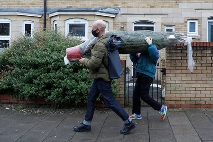Una familia carga un árbol de Navidad en Londres, Reino Unido. REUTERS/Peter Nicholls - RC25NK91YA9O