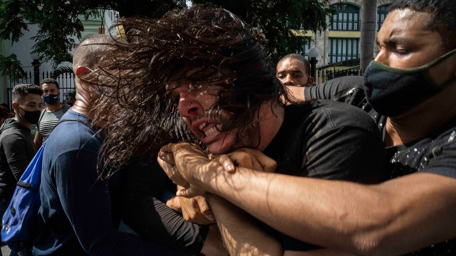 Policías de civil se llevan detenido a un joven manifestante en la capital cubana (AP)