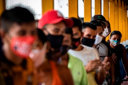 Personas hacen fila hoy para votar en el único centro electoral de la comunidad Lago do Catalao, en zona rural de Iranduba, Amazonas (Brasil). EFE / RAPHAEL ALVES

