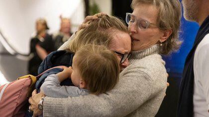 Families are reunited as travellers arrive on the first flight from Sydney, in Wellington on April 19, 2021, as Australia and New Zealand opened a trans-Tasman quarantine-free travel bubble. (Photo by Marty MELVILLE / AFP)