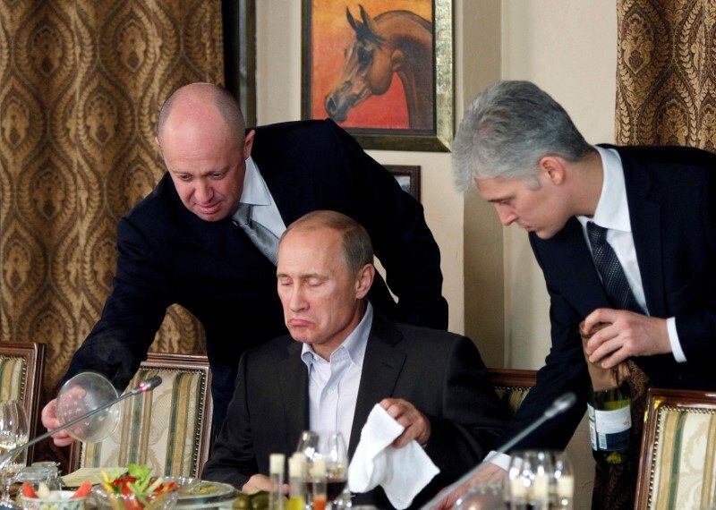 Prigozhin (izquierda) asiste a Vladímir Putin, durante una cena con académicos y periodistas extranjeros en el restaurante Cheval Blanc, en las instalaciones de un complejo ecuestre a las afueras de Moscú, el 11 de noviembre de 2011. Fotografía tomada el 11 de noviembre.  REUTERS/Misha Japaridze/Pool/Archivo