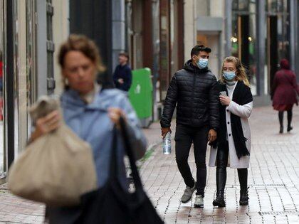 Personas con o sin máscaras caminan por una calle comercial mientras la enfermedad del coronavirus (COVID-19) continúa propagándose en Ámsterdam.