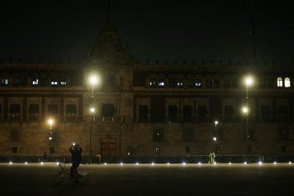 Un hombre toma fotos durante la noche frente al Palacio Nacional en Ciudad de México, México (Foto: REUTERS/Edgard Garrido)