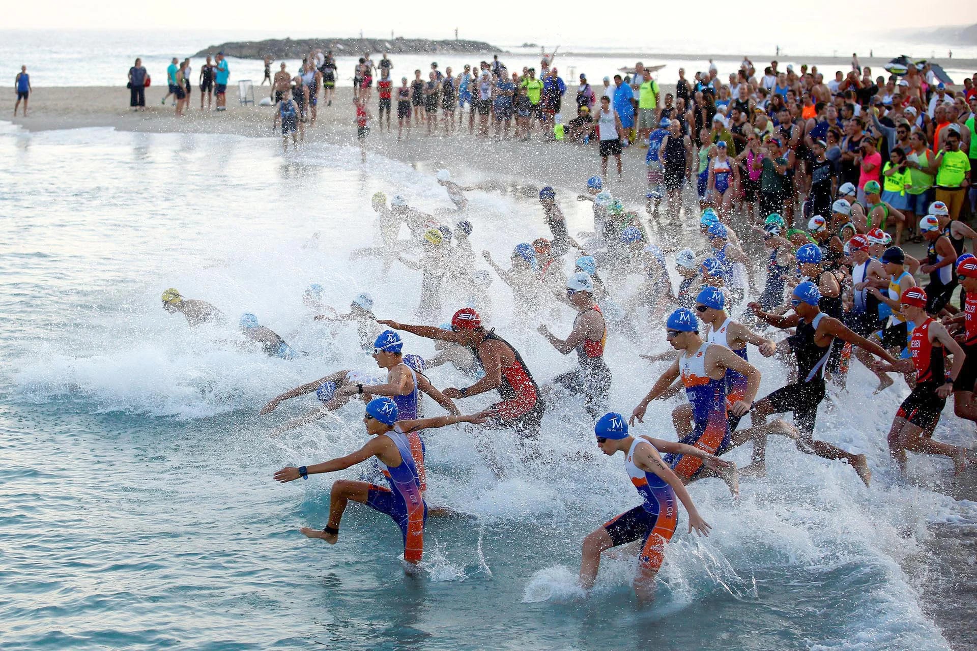 Participantes de un triatlón en Ashkelon, Israel, saltan al agua del mar Mediterráneo