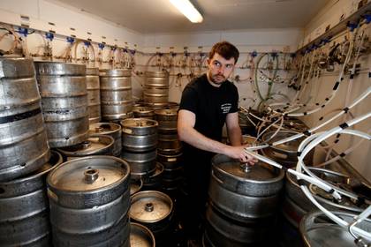 Ricky Keeen, encargado del Hatfield House Bar de Belfast, en Irlanda del Norte, muestra su depósito repleto de barriles sin usar y con su fecha de vencimiento que se va acercando.