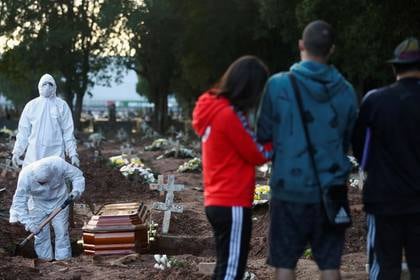 Un grupo de trabajadores y familiares en un cementerio en Río de Janeiro  durante el entierro de Neide Rodrigues, de 71 años, quien falleció de coronavirus. May 8, 2020. REUTERS/Pilar Olivares