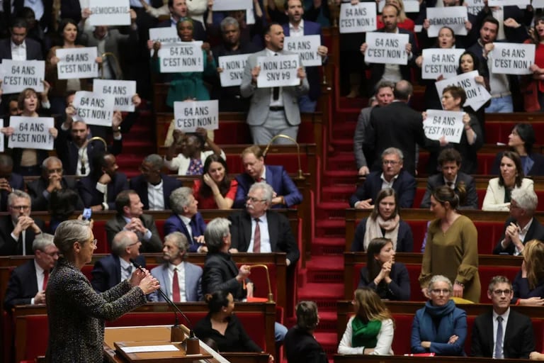  Miembros del parlamento francés muestran placas de rechazo a la reforma de pensiones, mientras la jefa del gabinete de  