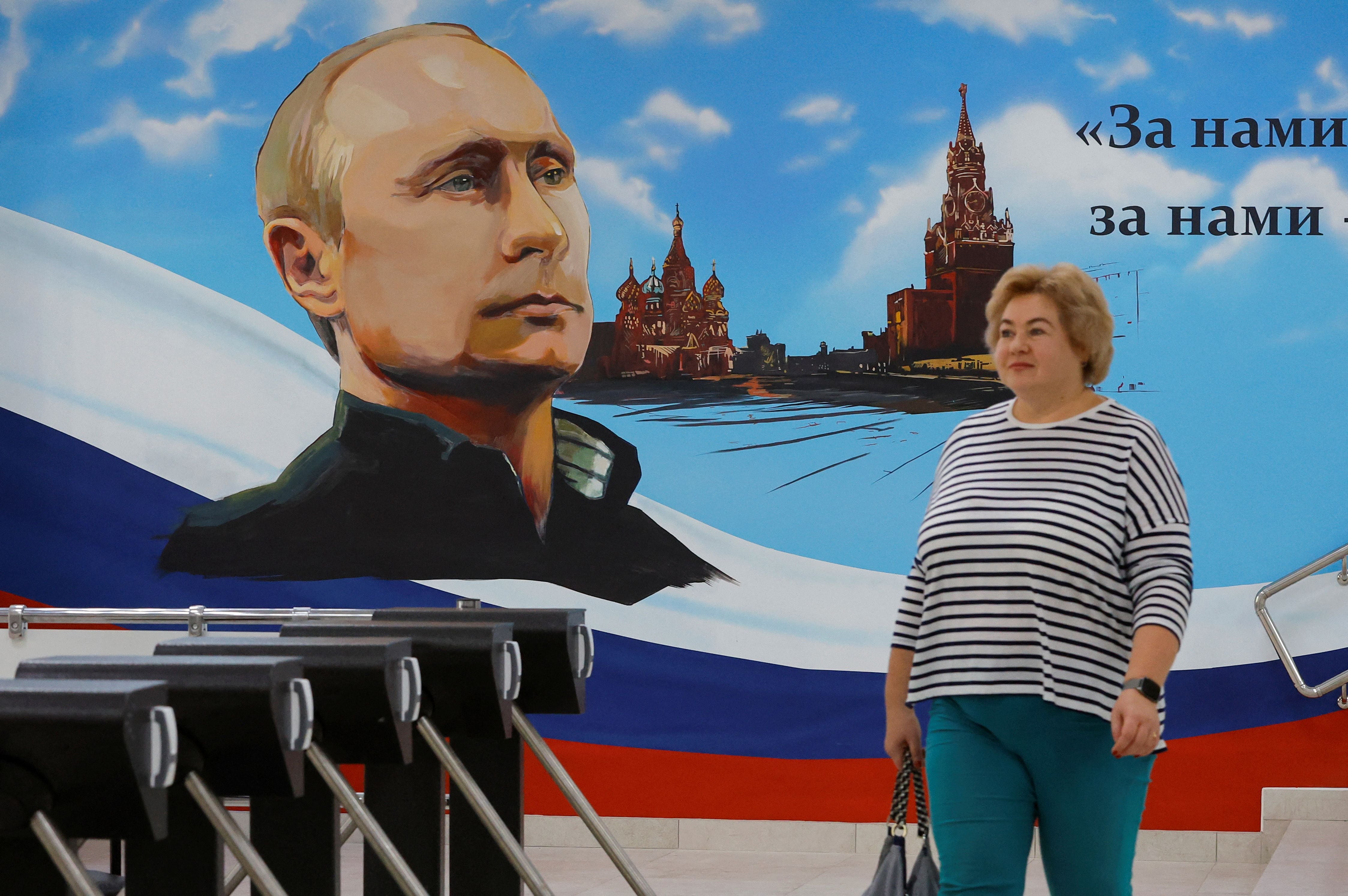 Un mural que representa al presidente ruso Vladimir Putin, la Catedral de San Basilio y la Torre Spasskaya del Kremlin de Moscú (reuters)